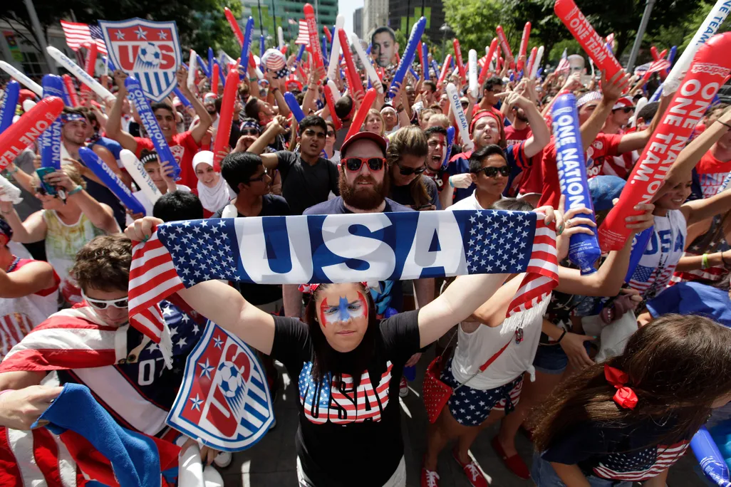 Amber Silvani holds up a USA banner as United States fans watch the 2014 World Cup soccer match