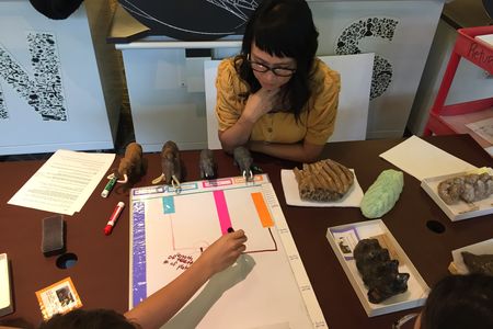 Education Specialist Gale Robertson helps museum visitors test prototypes of hands-on activities that will be in “The David H. Koch Hall of Fossils—Deep Time” when it opens June 8 at the Smithsonian’s National Museum of Natural History. (Smithsonian Institution)  
