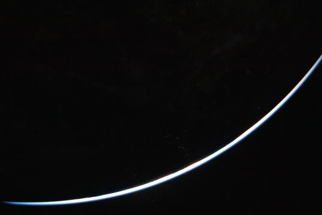 Curved light blue line, showing a sliver of Earth illuminated