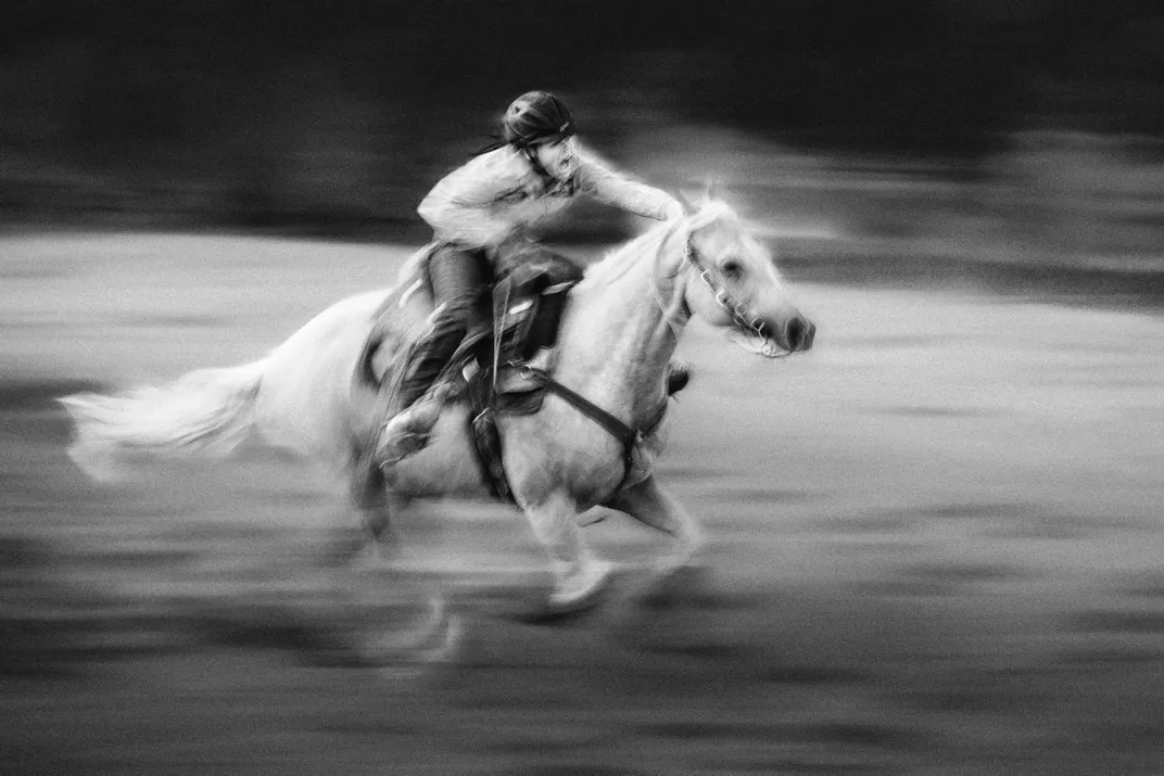 A barrel race competitor moves quickly through the obstacle course.