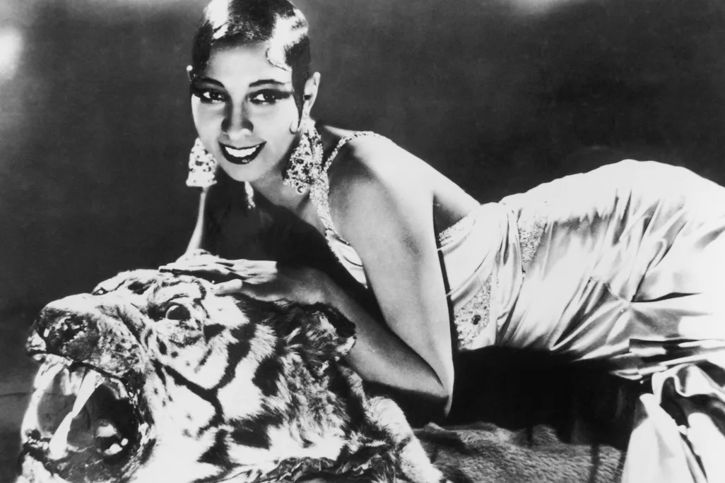 Josephine Baker lying on a tiger rug in a silk evening gown in 1925