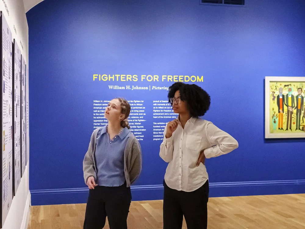 Visitors look at a timeline of William H. Johnson's life