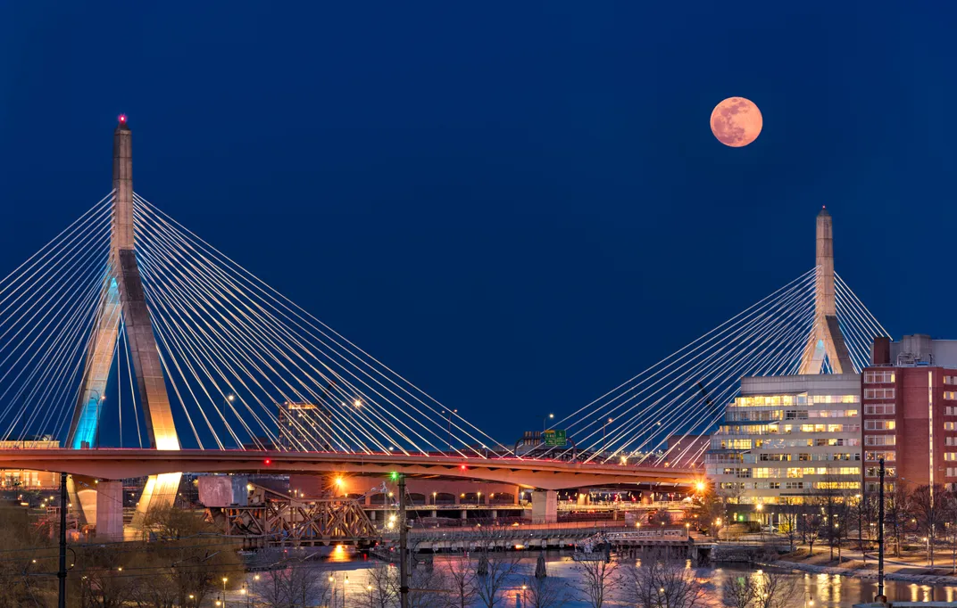 A supermoon rises over Zakim Bunker Hill Memorial Bridge.