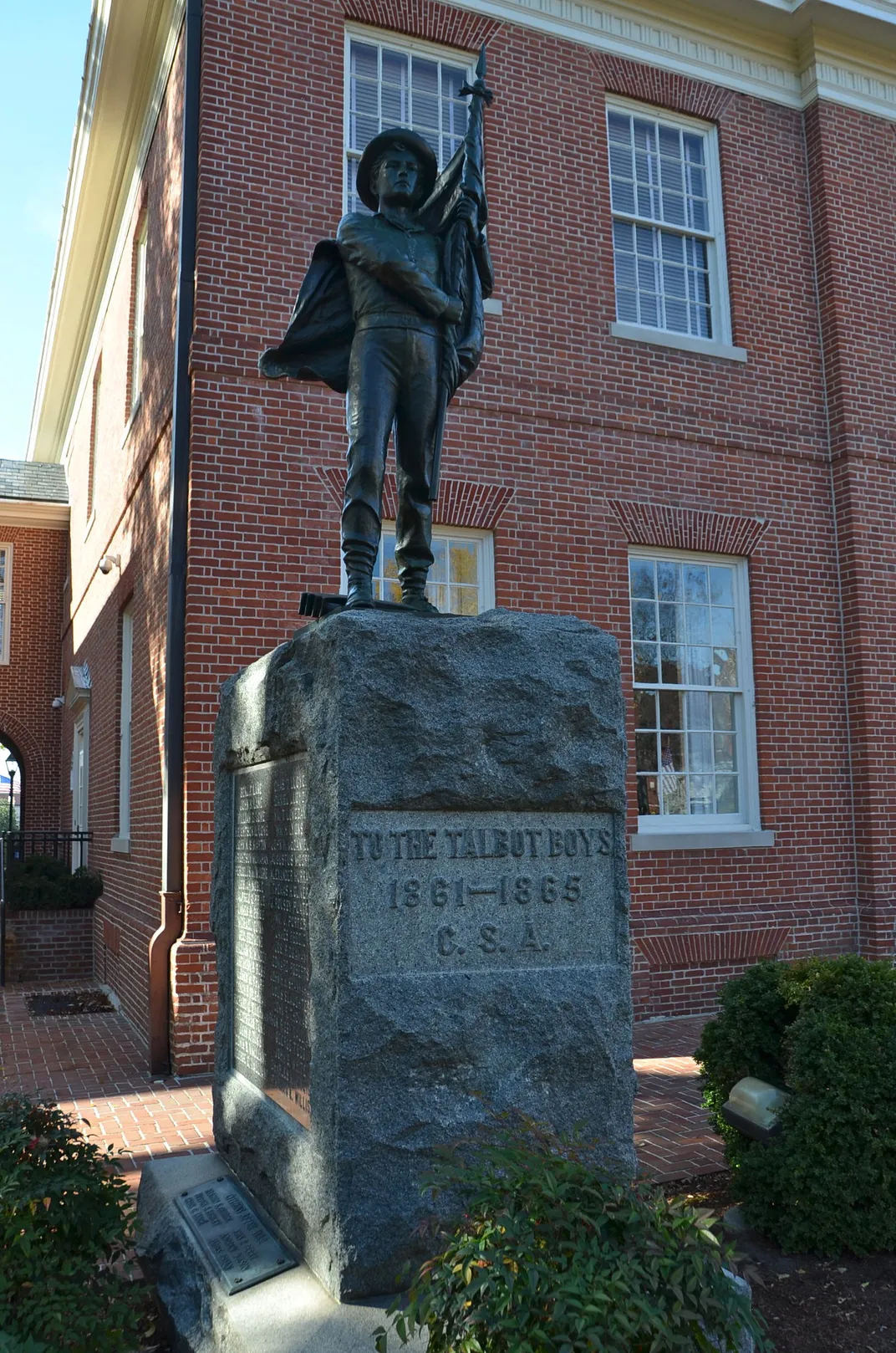 A statue of a young boy holding a Confederate flag, atop a plinth that reads TO THE TALBOT BOYS