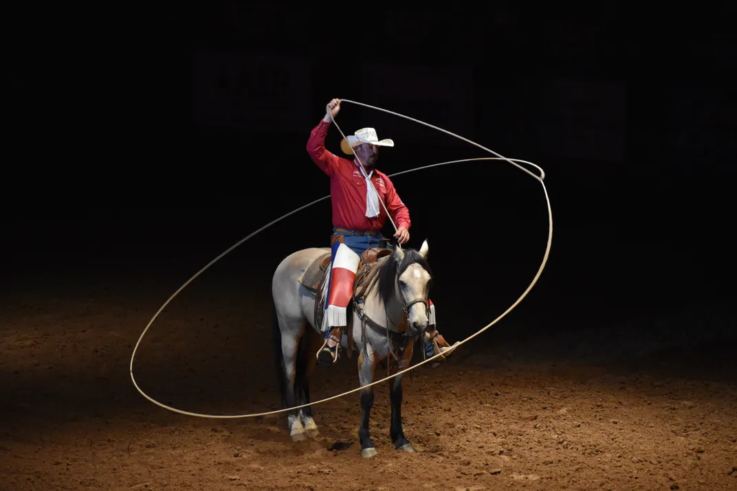 A cowboy clad in red, white and blue shows off his lasso rope skills at the Stockyards rodeo.