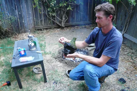Study co-author Kevin Smith applies melted bitumen to a bottle, following a technique used by indigenous groups of the California Channel Islands. 