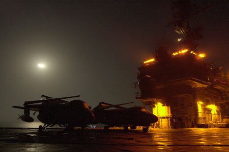 Lights from the USS Kitty Hawk island structure create an eerie cast over two S-3 Viking aircraft on a misty Halloween night.  Kitty Hawk operates out of Yokosuka, Japan as America's only permanently forward-deployed aircraft carrier.  (U.S. Navy photo by Photographer's Mate Airman Michael D. Winter)  (Released)..