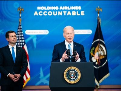 Transportation Secretary Pete Buttigieg listens as President Joe Biden delivers remarks about requiring airlines to compensate passengers for extensive flight delays and cancellations.