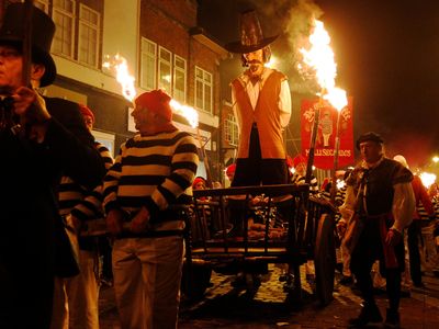 Participants in costume process with an effigy of Guy Fawkes, to be burned, as they take part in one of a series of processions during Bonfire night celebrations in Lewes, southern England.