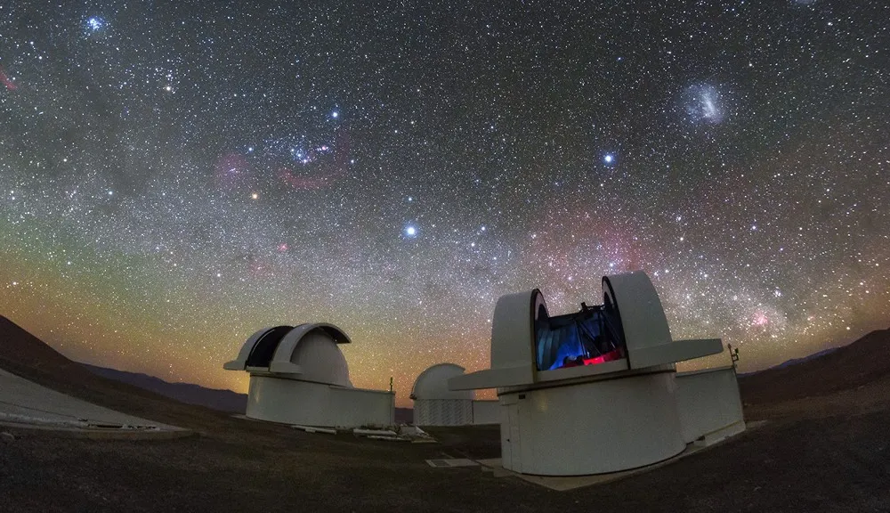 A pair of telescopes in the Atacama Desert in Chile gaze up at a starry night sky.
