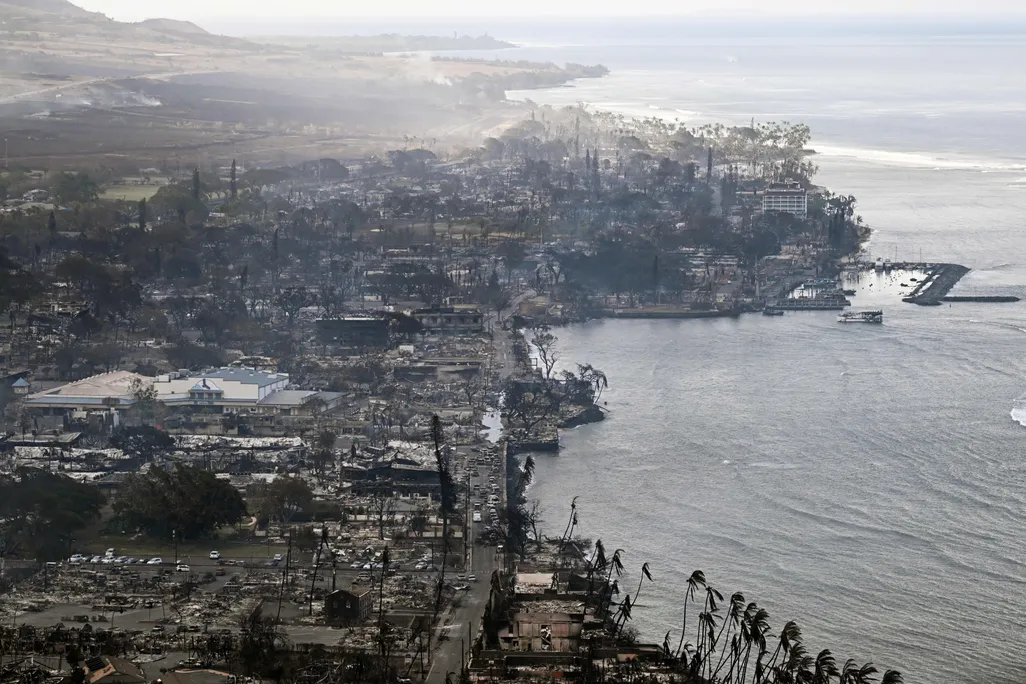 smoke floats above a scorched coastal, developed landscape