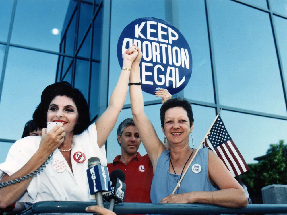 律师Gloria Allred(左)和Norma McCorvey(右)，Roe v. Wade案件的匿名原告，于1989年7月4日在加州伯班克的一场支持堕胎的集会上