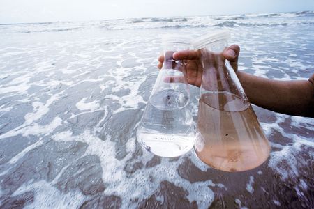 Seawater contains hundreds of viruses, revealed with dye in the flask on the right. Most are harmless, but some microbes living under the sea and amid the sand aren't. 