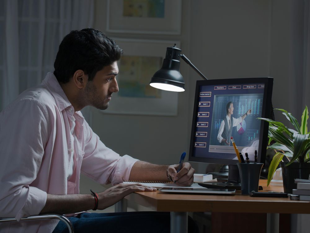 Stock photo image of a man watching a generic lecture on a desktop computer screen