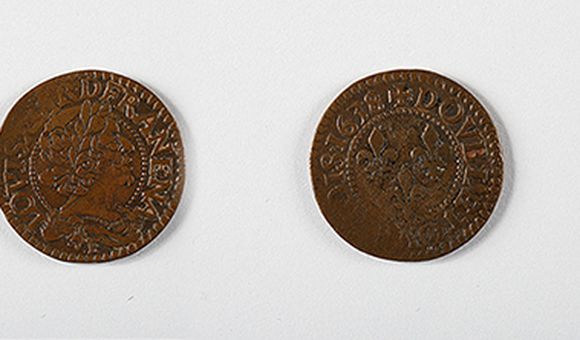 A team of Smithsonian scientists excavating the Hart Chalet site found a double tournois copper coin minted for French King louis XIII in 1634.  In pristine condition, it would have looked similar to this 1638 double tournois coin. (Images courtesy of the National Numismatic Collection, National Museum of American History, Smithsonian Institution. Image composite by Anna Torres)