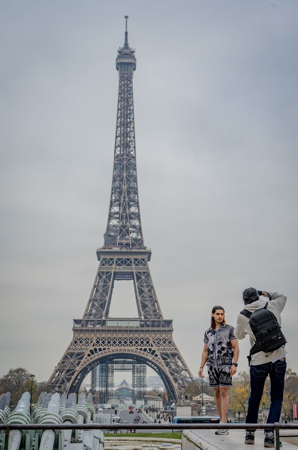 A man poses in front of the Eiffel Tower thumbnail
