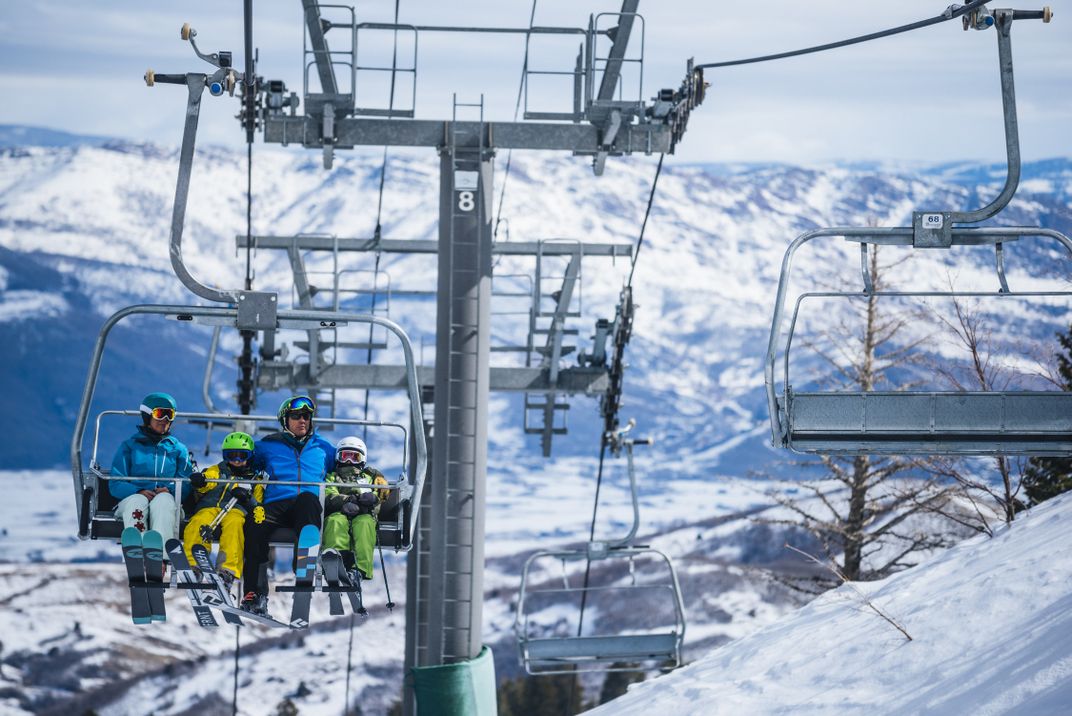 People riding a chairlift at a ski resort