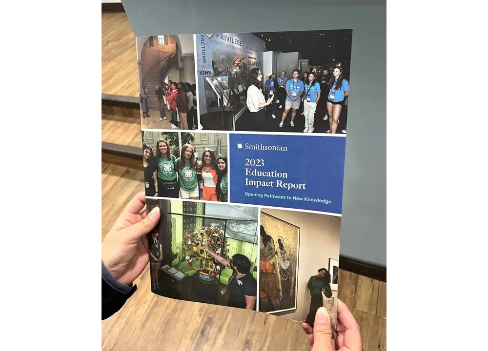 Hard-copy of the FY2023 Smithsonian Education Impact Report held in someone’s hands.