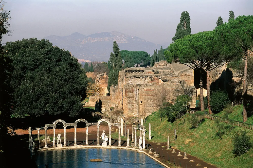 A view of a shallow pool of water with columns and crumbling structures extending behind