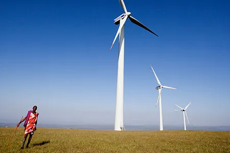 A young Maasai stands in front of a wind turbine on the Ngong Hills in Kenya.