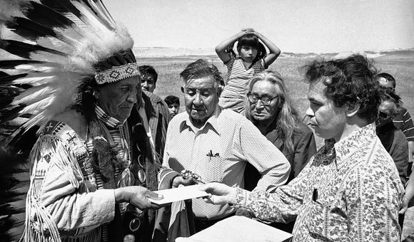 Hank Adams carries a letter from the White House to Chief Frank Fools Crow (Oglala Lakota) during the siege of Wounded Knee. Pine Ridge Reservation, South Dakota, 1973. (Hank Adams Collection)