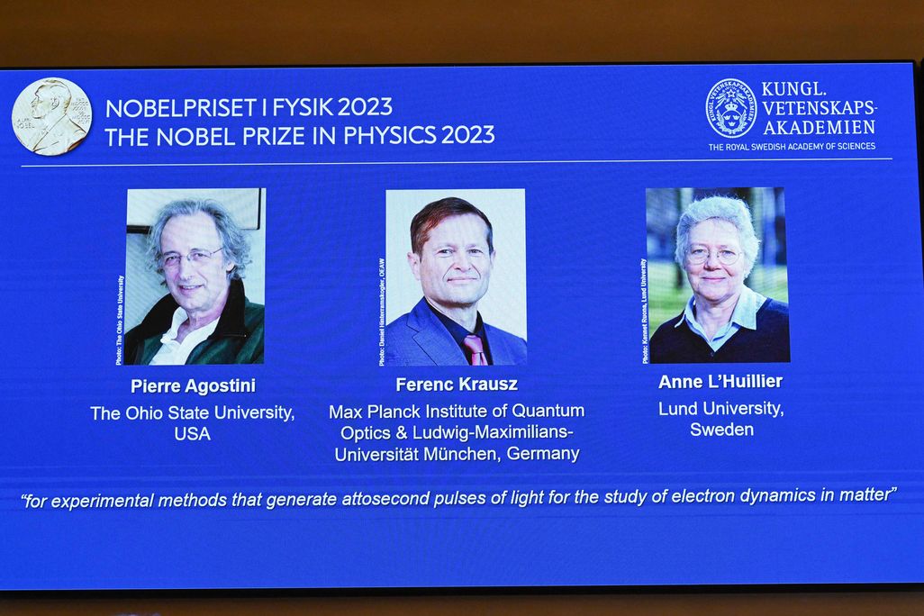 An image on a projector screen with photos of the three recipients of the 2023 Nobel Prize in Physics