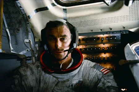 Apollo 17 mission commander Eugene Cernan inside the lunar module on the moon after his second moonwalk of the mission. His spacesuit is covered with lunar dust.