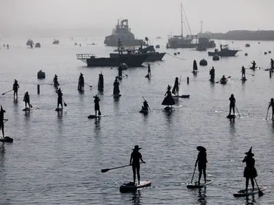 Why Are Witches and Warlocks Going Stand-Up Paddleboarding to Celebrate Halloween? image