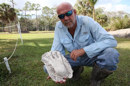 Shealy poses with a cast of a Skunk Ape footprint he says he made in 1998.