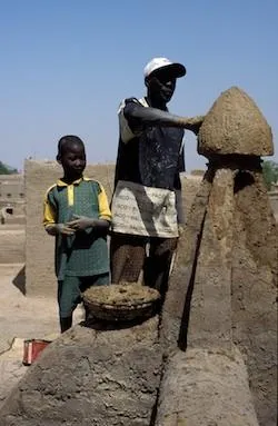 A mason finishes a rooftop decoration.