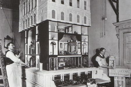 Workers furnish Queen Mary's Dollhouse in the drawing room of Lutyen's London apartment