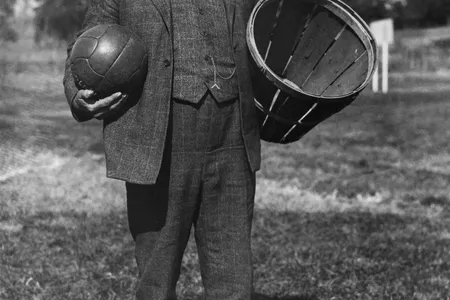 James Naismith, the inventor of basketball, holding a soccer ball and a basket