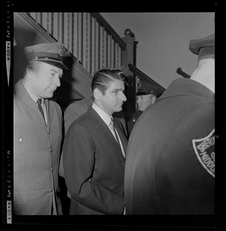 Albert DeSalvo is escorted by police officers during his trial