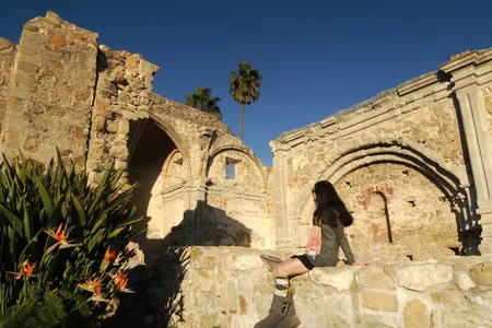 A woman sits amid the ruins of the Great Stone Church, which collapsed in an 1812 earthquake, at Mission San Juan Capistrano.