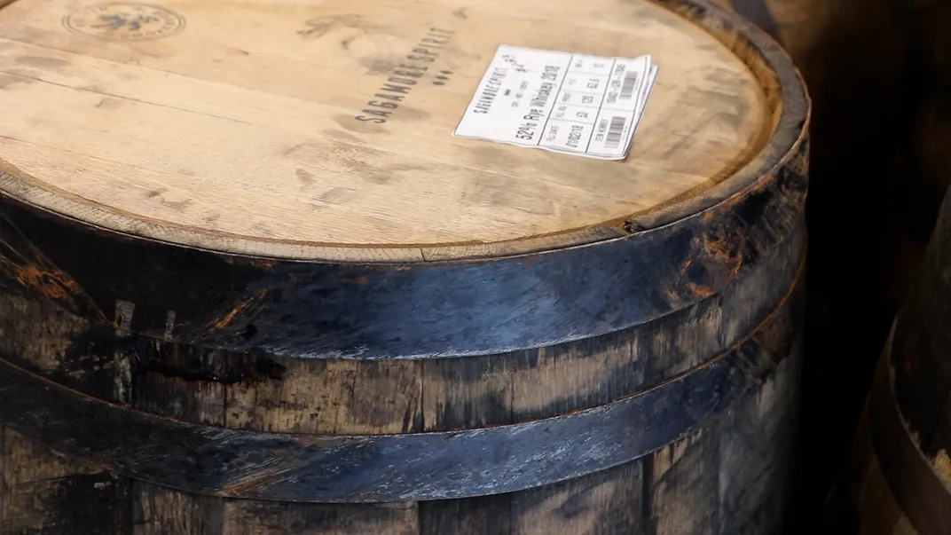 Close-up of a charred wooden barrel with metal rings around it