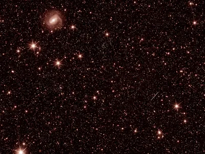 A test image taken by Euclid&#39;s infrared light instrument showing distant stars and galaxies.