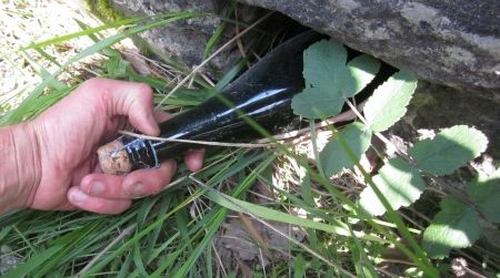 A hidden treasure–a bottle of Normandy apple cider stashed eight months earlier–is withdrawn from a hole in a rock wall in France’s Dordogne Valley. It was replaced with a Chimay Belgian ale. Want to play the game? Read this post for instructions.