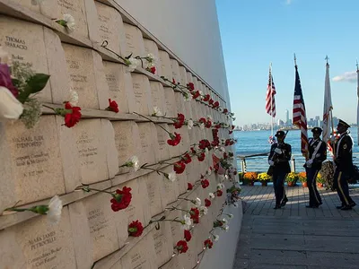 On the inner wall of one of the two "wings" comprising Masayuki Sono's Postcards monument in Staten Island, flowers are placed next to the names of victims of the 9/11 attacks. 