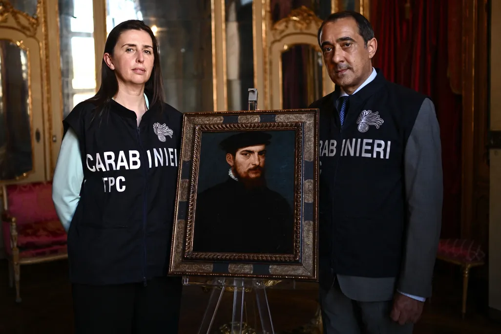Members of the Carabinieri Police Cultural Heritage Protection Unit pose with a painting