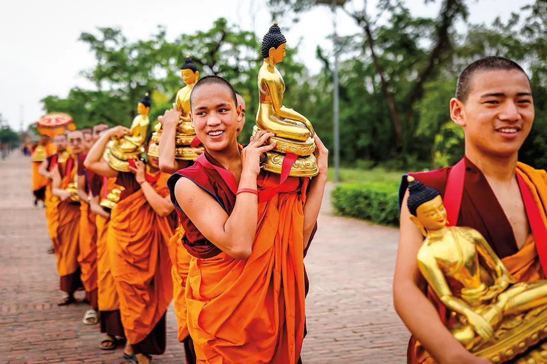 Tibetan Buddhist monks carry statues