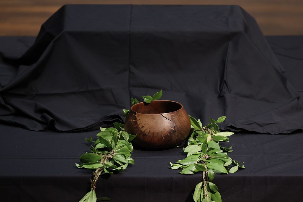 Covered in black cloth, a box containing human remains sits on a table during a repatriation ceremony in Berlin on February 11, 2022