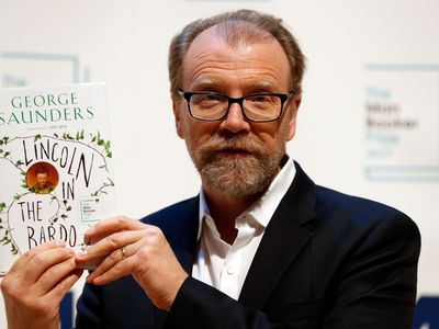 George Saunders poses with his book Lincoln in the Bardo, which won the 2017 Man Booker Prize for Fiction.