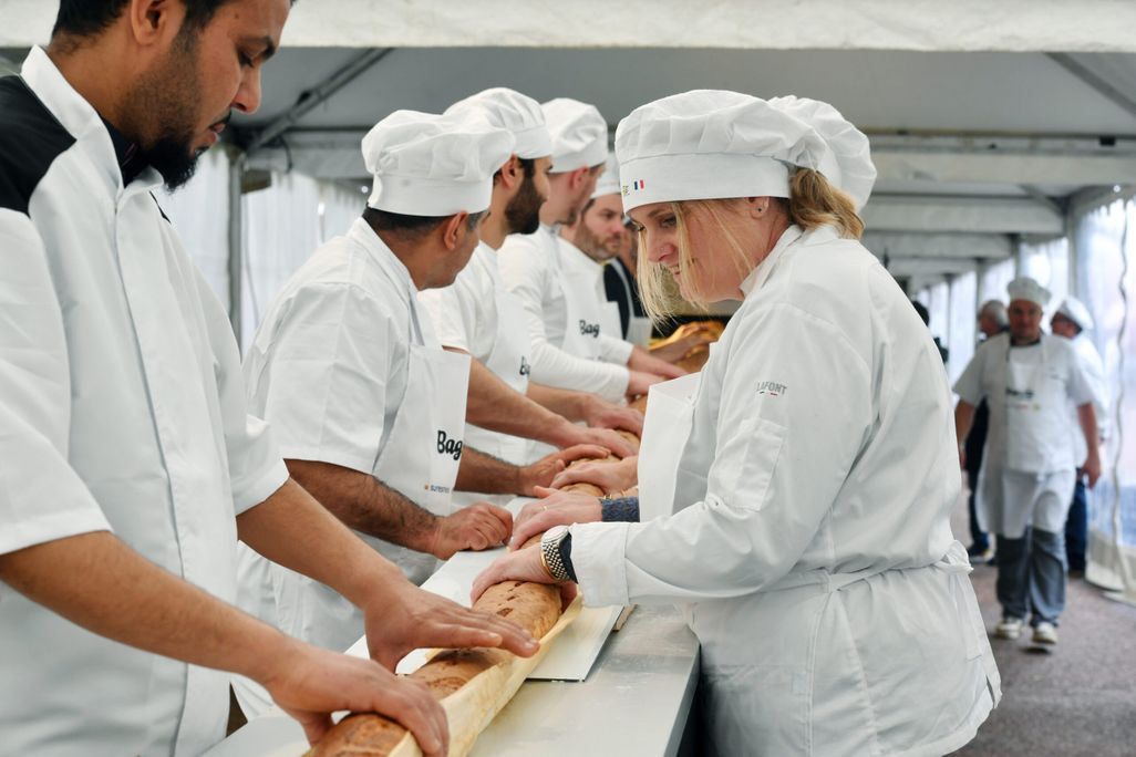 French bakers holding a long baguette
