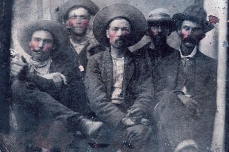 The image depicts the outlaw Billy the Kid, posing alongside the sheriff who later killed him.