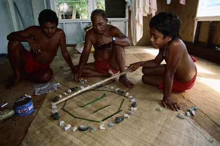 Master navigator Mau Piailug teaches navigation to his son and grandson with the help of a star compass.