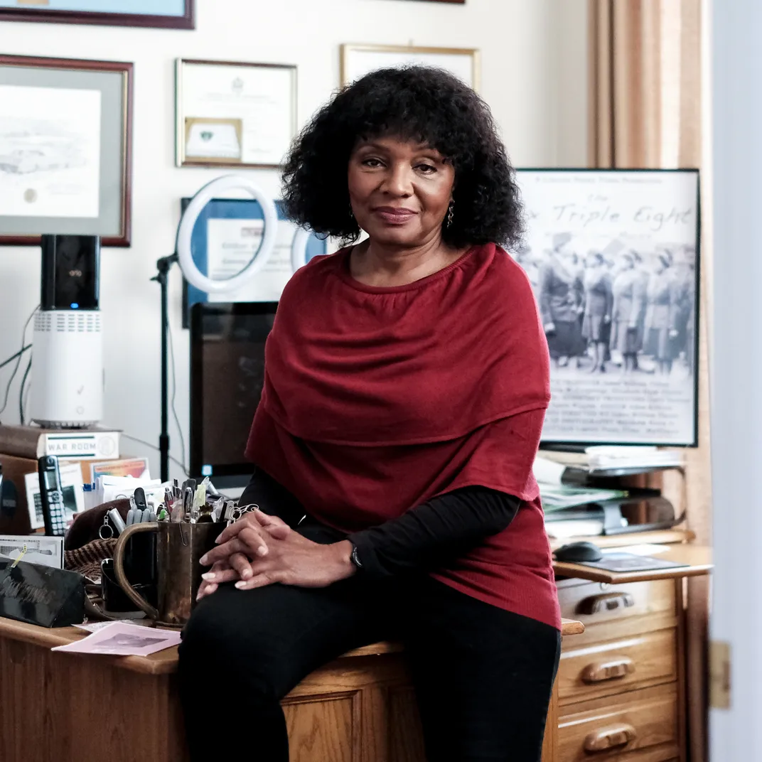 a Black woman sits for a portrait in her home office