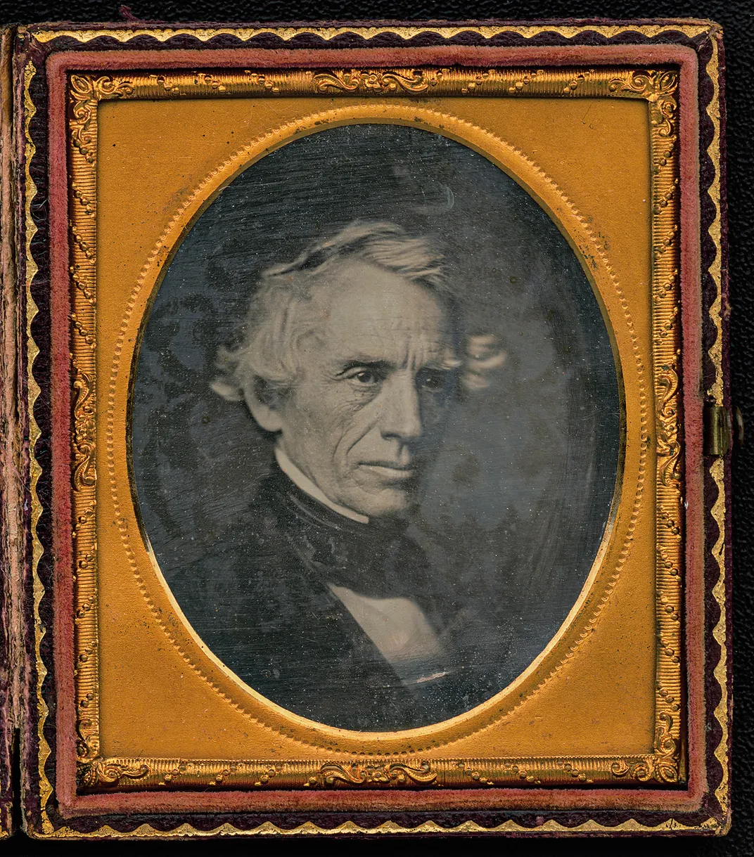 a tintype portrait of a man in a detailed frame