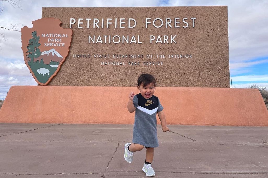 Toddler in front of national park sign