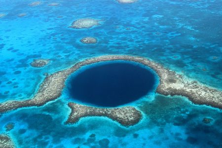 Blue holes, like the Great Blue Hole in Belize, are vast caverns that descend into the seafloor. Sediment accumulates at the bottom of a blue hole, giving researchers a way to gauge historical hurricane activity.