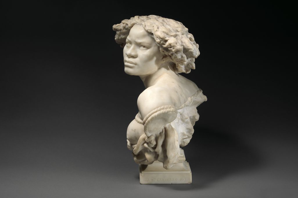 Another perspective of the sculpture of the enslaved Black woman, with her eyes fixed on the viewer